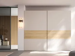 Sliding wardrobe with Maya door. Interior in Oak, doors in matte lacquered Sand and textured Oak.