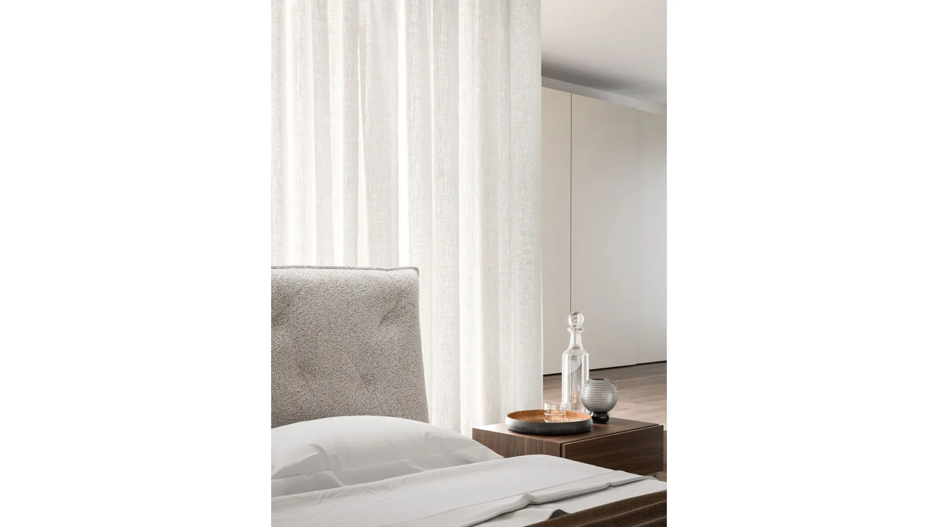 Double bedroom with Bed Fiocco with fabric bed frame and night group in cotto material.