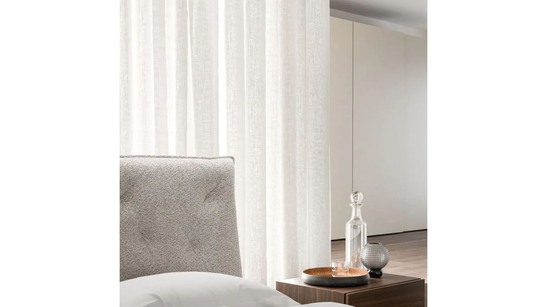 Double bedroom with bed Fiocco with fabric bed frame and night group in textured Cotto.