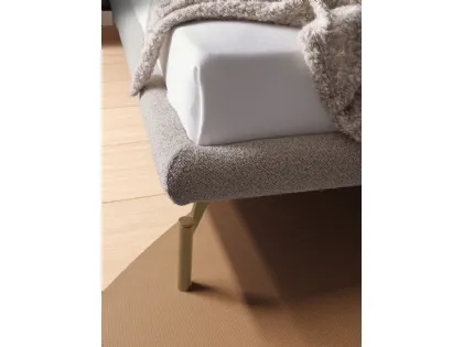 Double bed model Alissa with upholstered bed frame and Palladio lacquered metal foot.