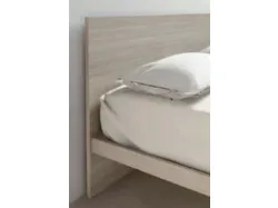 Double bed with headboard, version with slanted feet, customizable finishes.