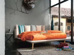 Modern double bed with original headboard with six pillows.