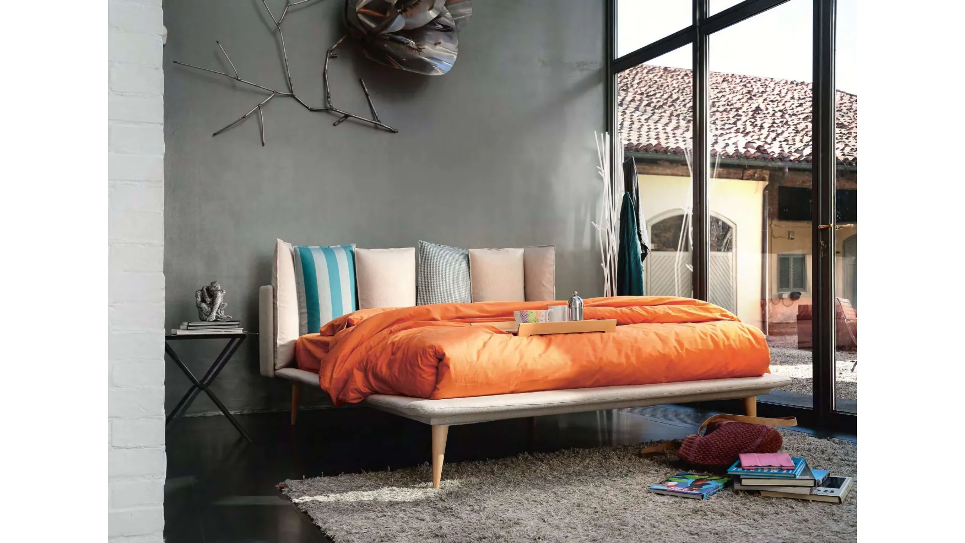 Modern double bed with original headboard with six pillows.