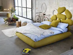 Double bed with headboard in wood cut with a pantograph, covered with soft rubber.