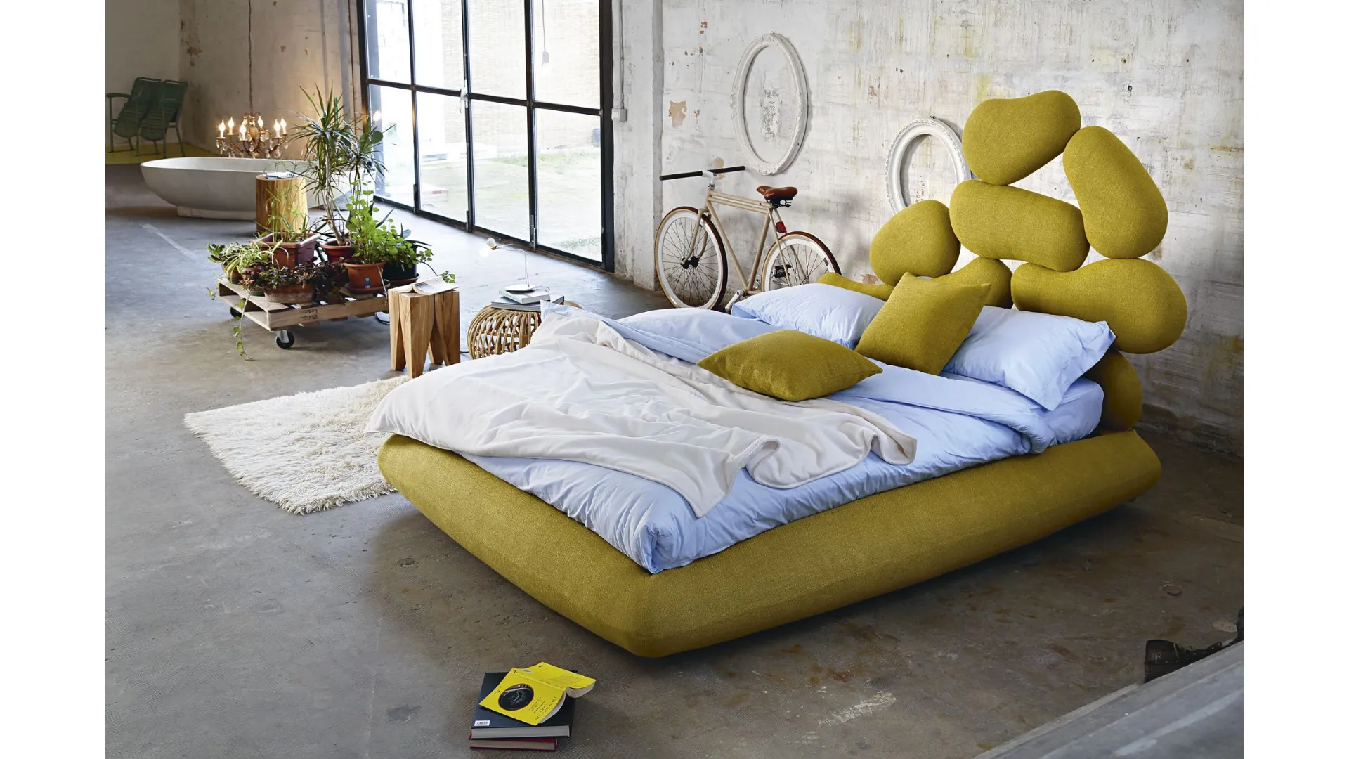 Double bed with headboard in wood cut with a pantograph, covered with soft rubber.
