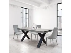 Extendable laminate table with X-shaped design legs and two lateral extensions.