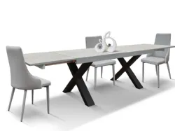 Extendable laminated table with X-shaped designer legs and two side extensions.